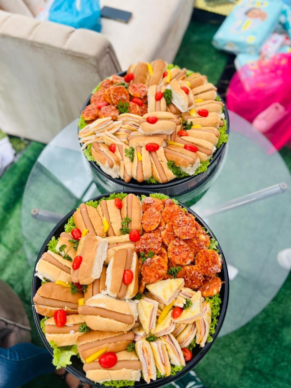 Platters of hot dog rolls, club sandwiches and spicy chicken