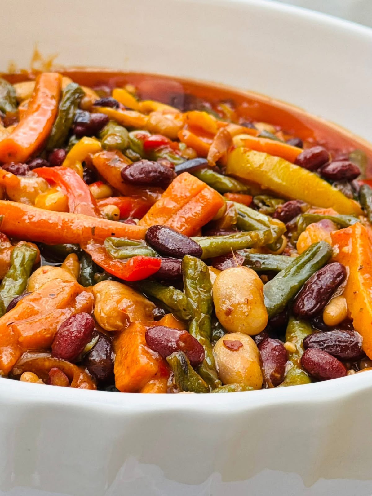 Three bean and vegetable salad in a white serving dish